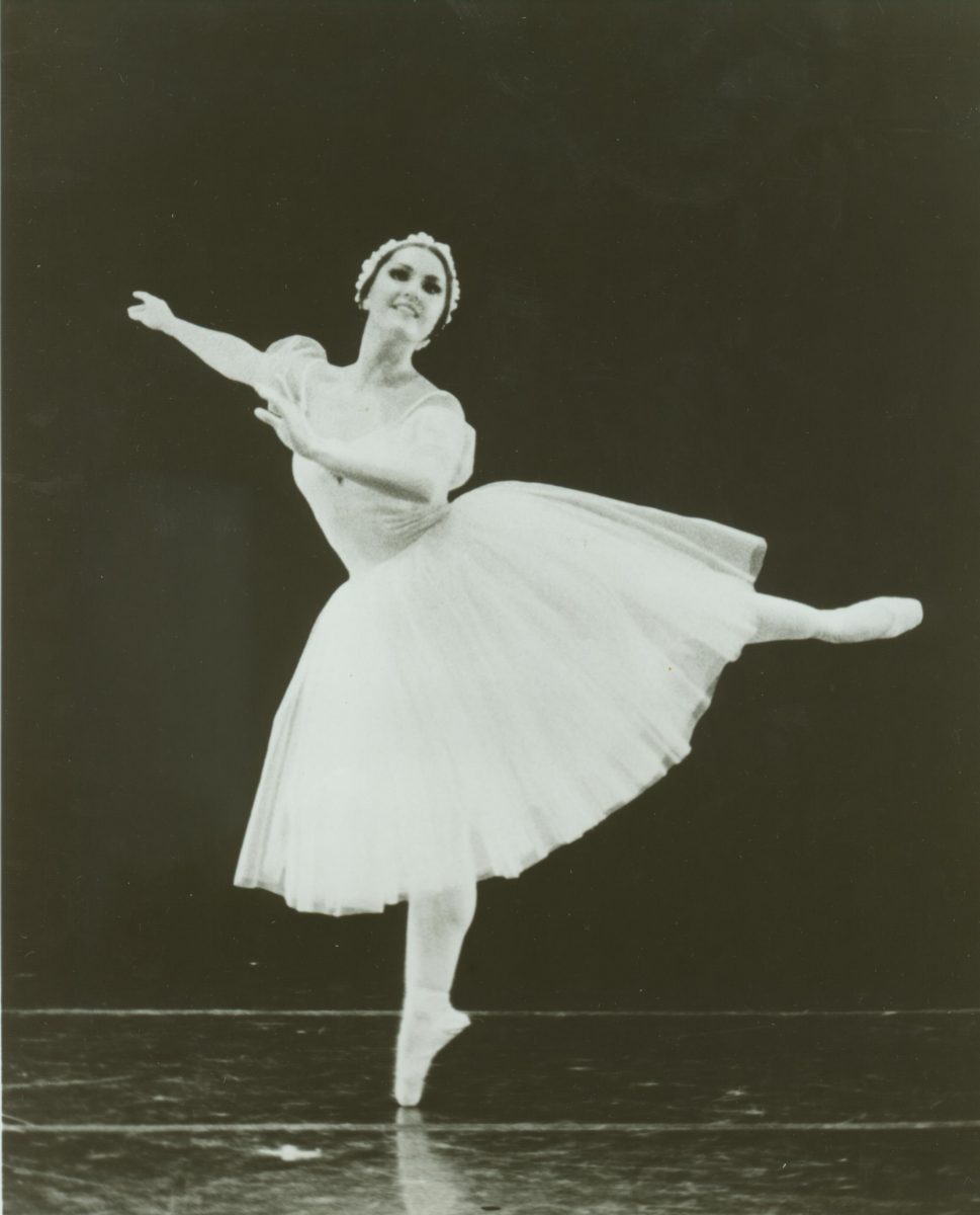 A scan of a black and white photo of Ernesta Corvino in a white costume dancing on stage