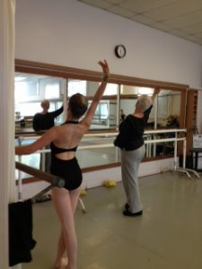 Beth Hoge giving corrections during class with a teen student practicing next to her.