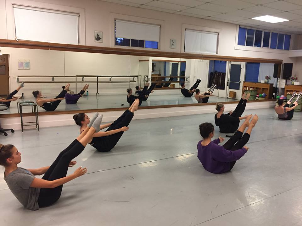 5 dancers in the studio in a v sit during Intermediate Advanced Modern Jazz