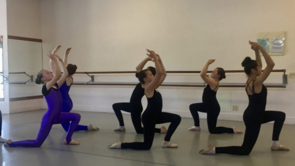 6 dancers kneeling with arms reaching up to the ceiling in a summer performance in Danspace's studio 1